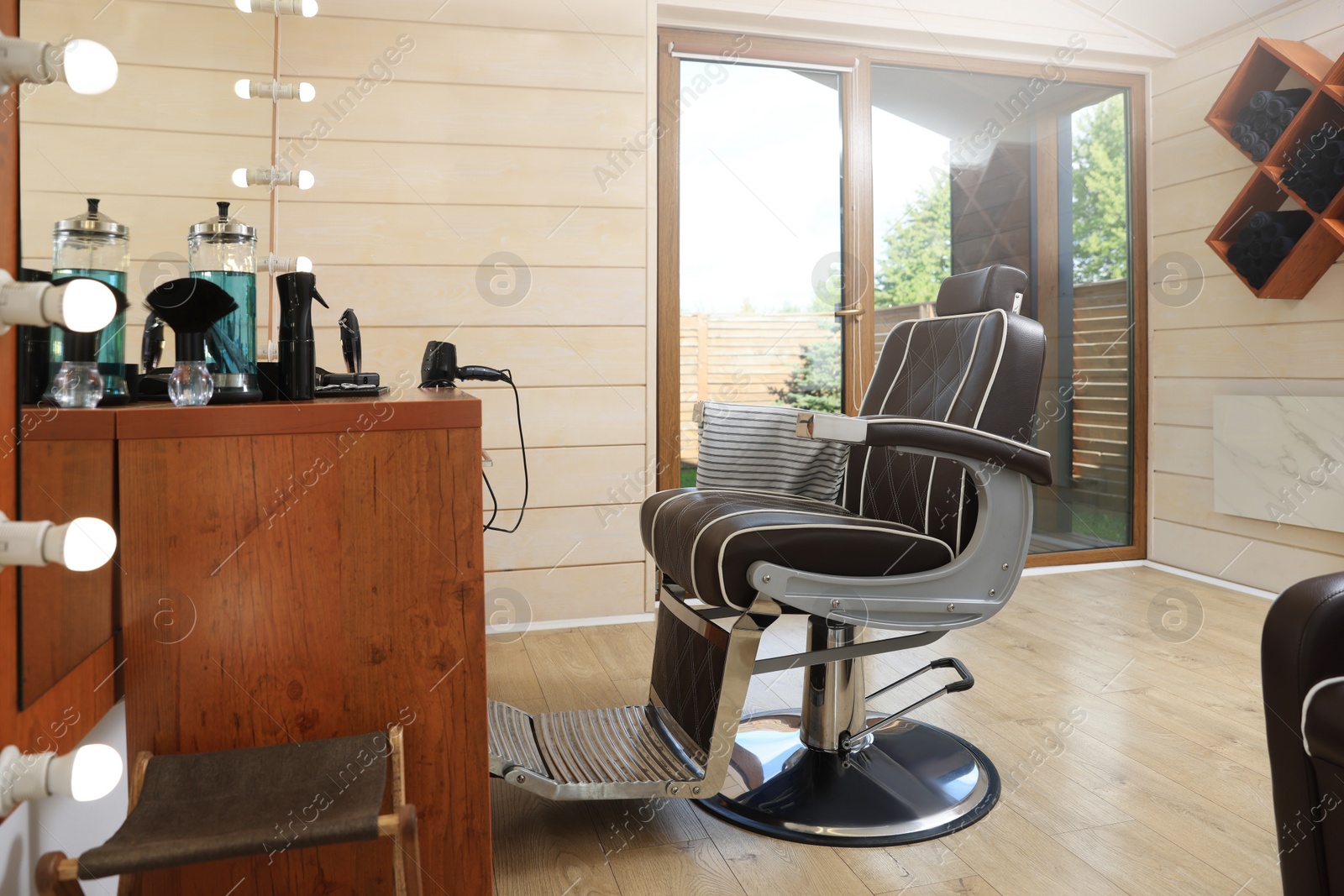 Photo of Stylish hairdresser's workplace with professional armchair in barbershop