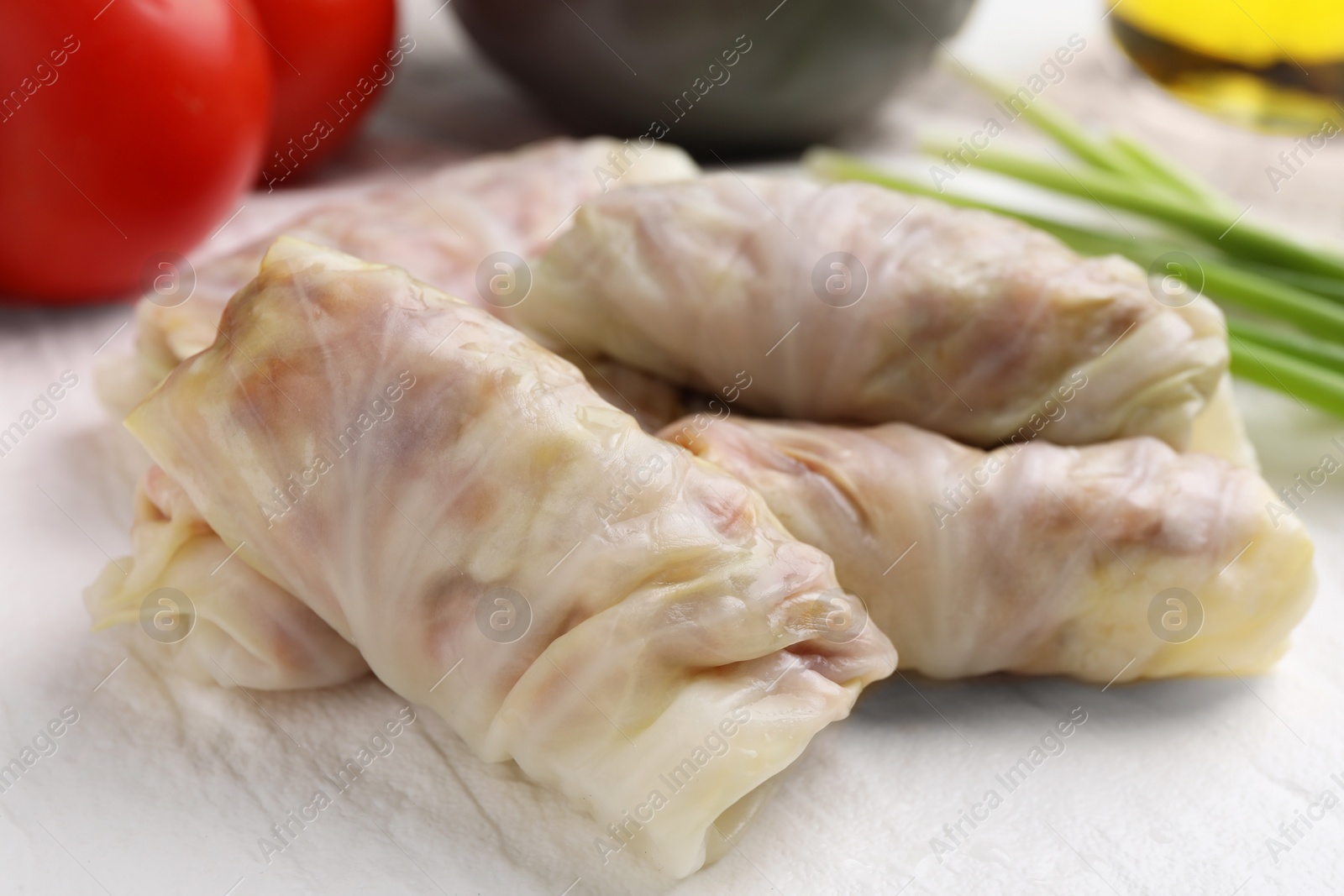 Photo of Uncooked stuffed cabbage rolls on plate, closeup