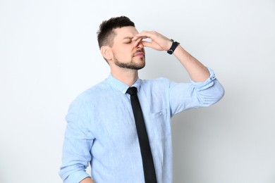 Photo of Man suffering from runny nose on white background
