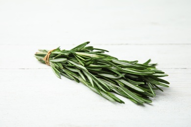 Bunch of fresh rosemary on white wooden table