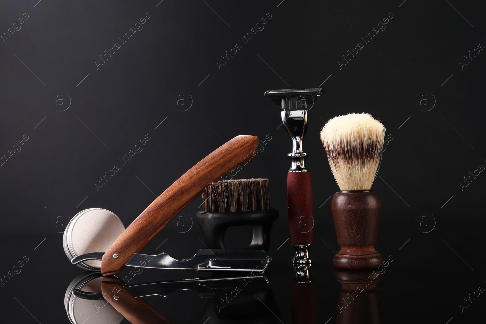 Photo of Moustache and beard styling tools on black mirror surface