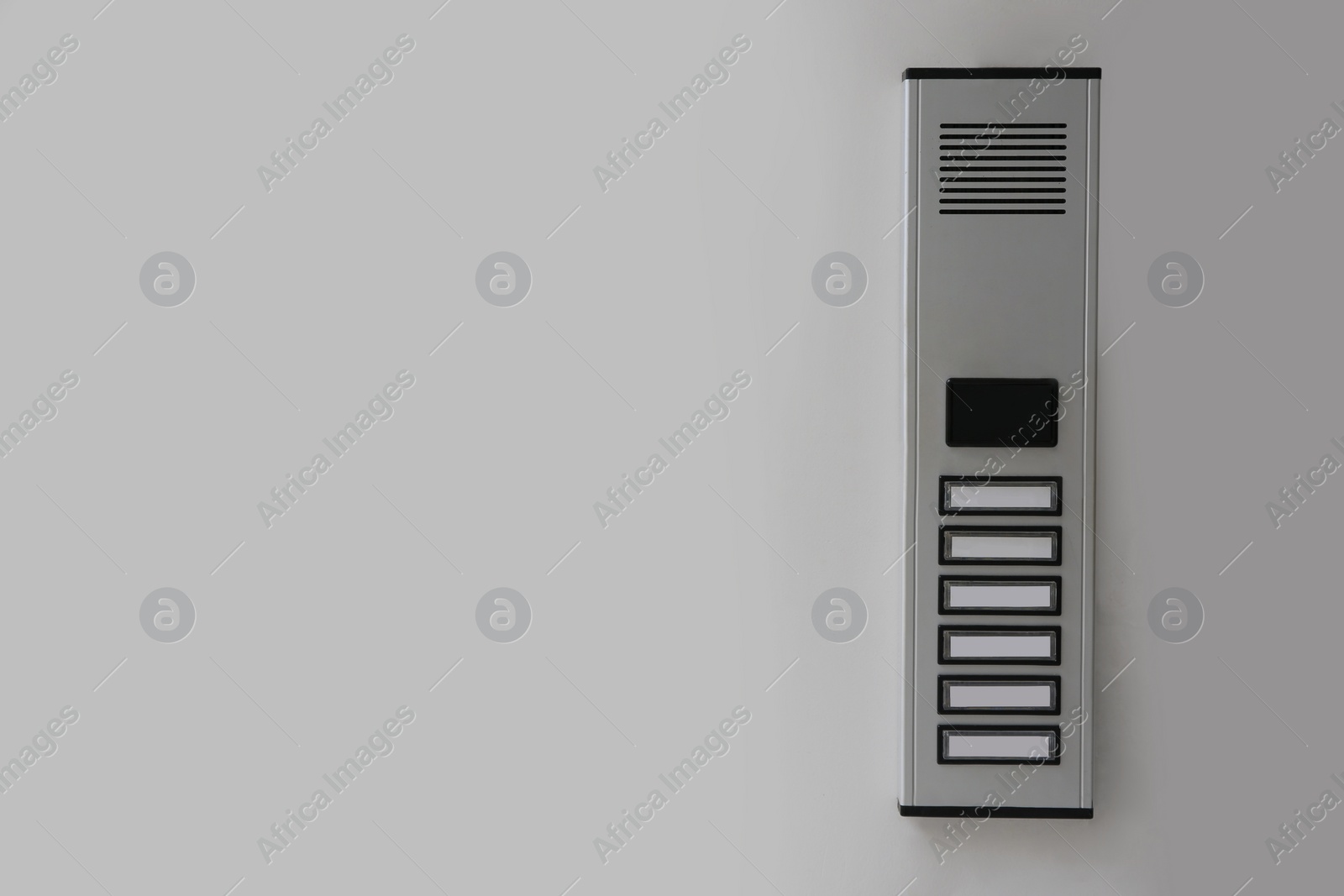 Photo of Modern intercom on white wall, space for text. Security system