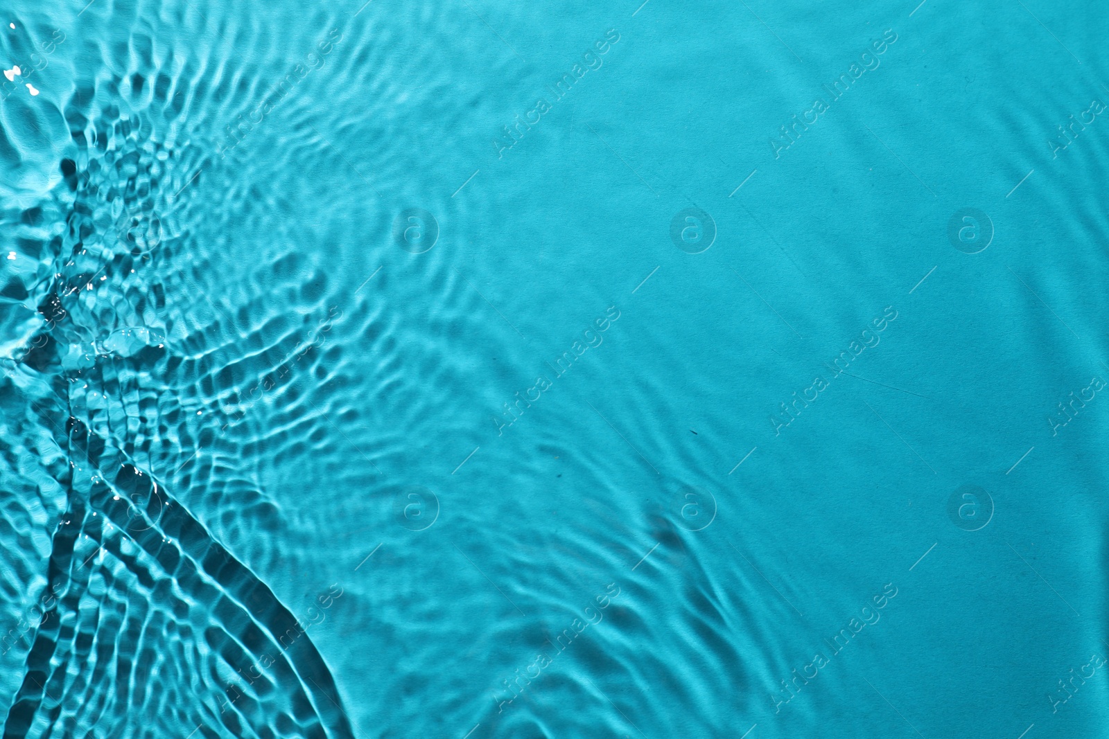 Photo of Rippled surface of clear water on light blue background, top view