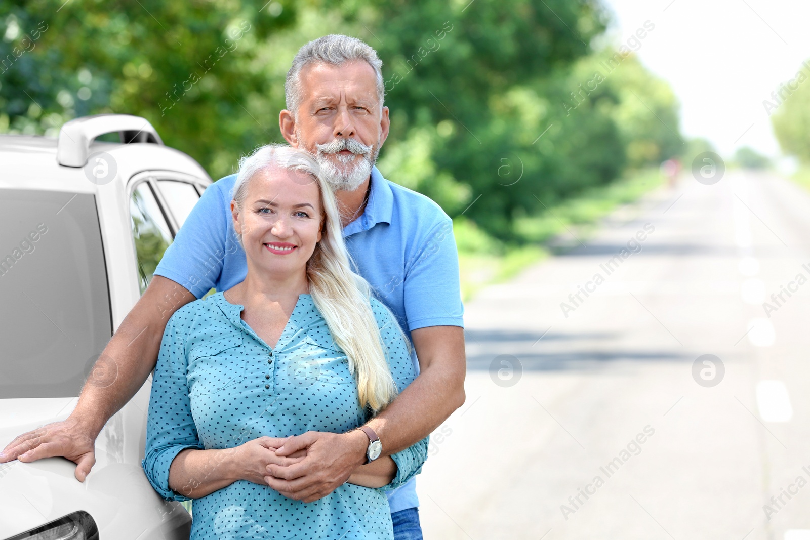 Photo of Happy senior couple posing near car outdoors