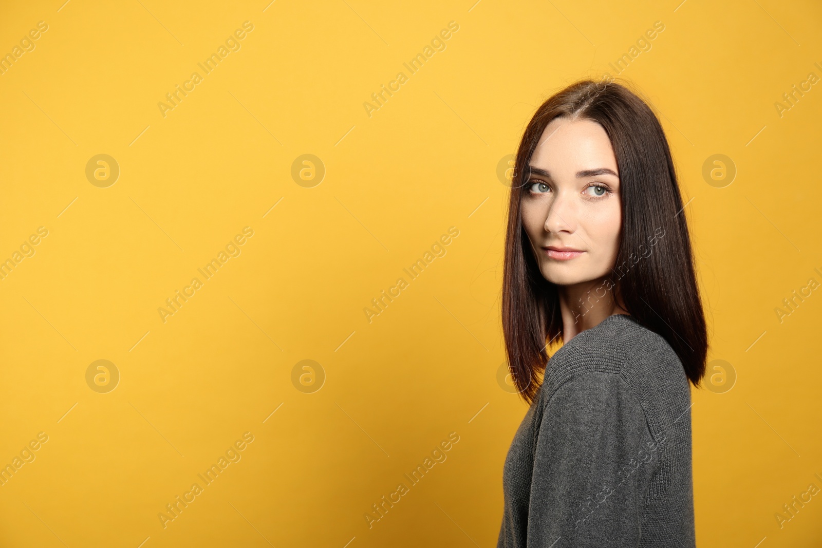 Photo of Portrait of pretty young woman with gorgeous chestnut hair on yellow background, space for text