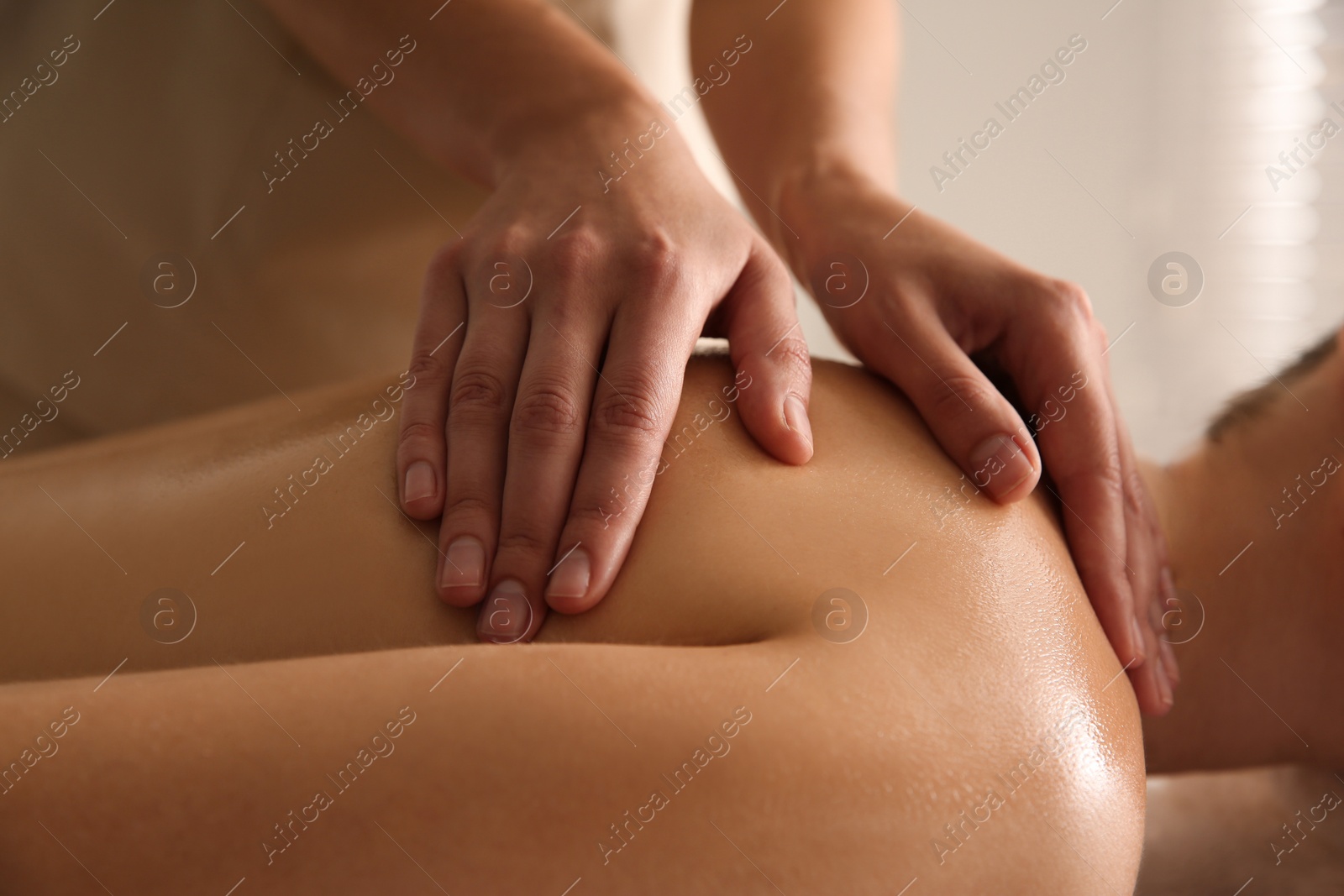 Photo of Young woman receiving back massage in spa salon, closeup