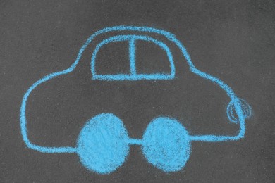 Child's chalk drawing of car on asphalt, top view