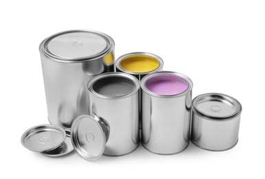 Photo of Cans of yellow, lilac and grey paints on white background