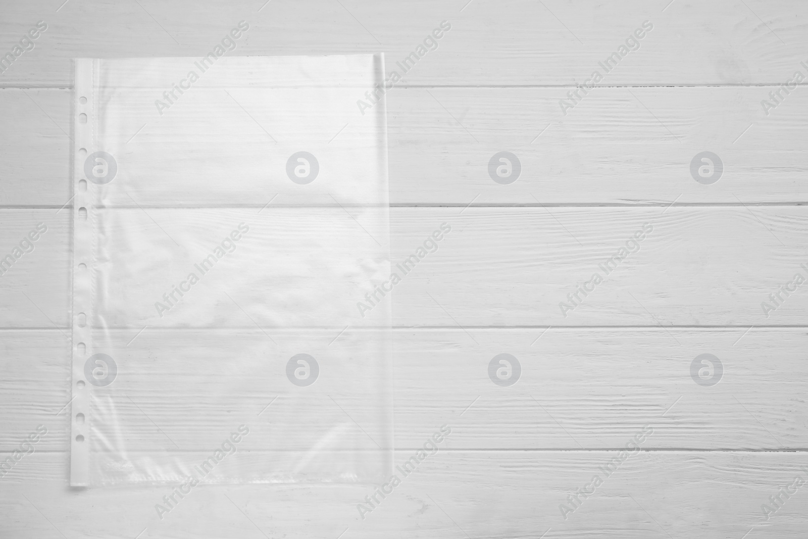 Photo of Punched pocket on white wooden table, top view. Space for text