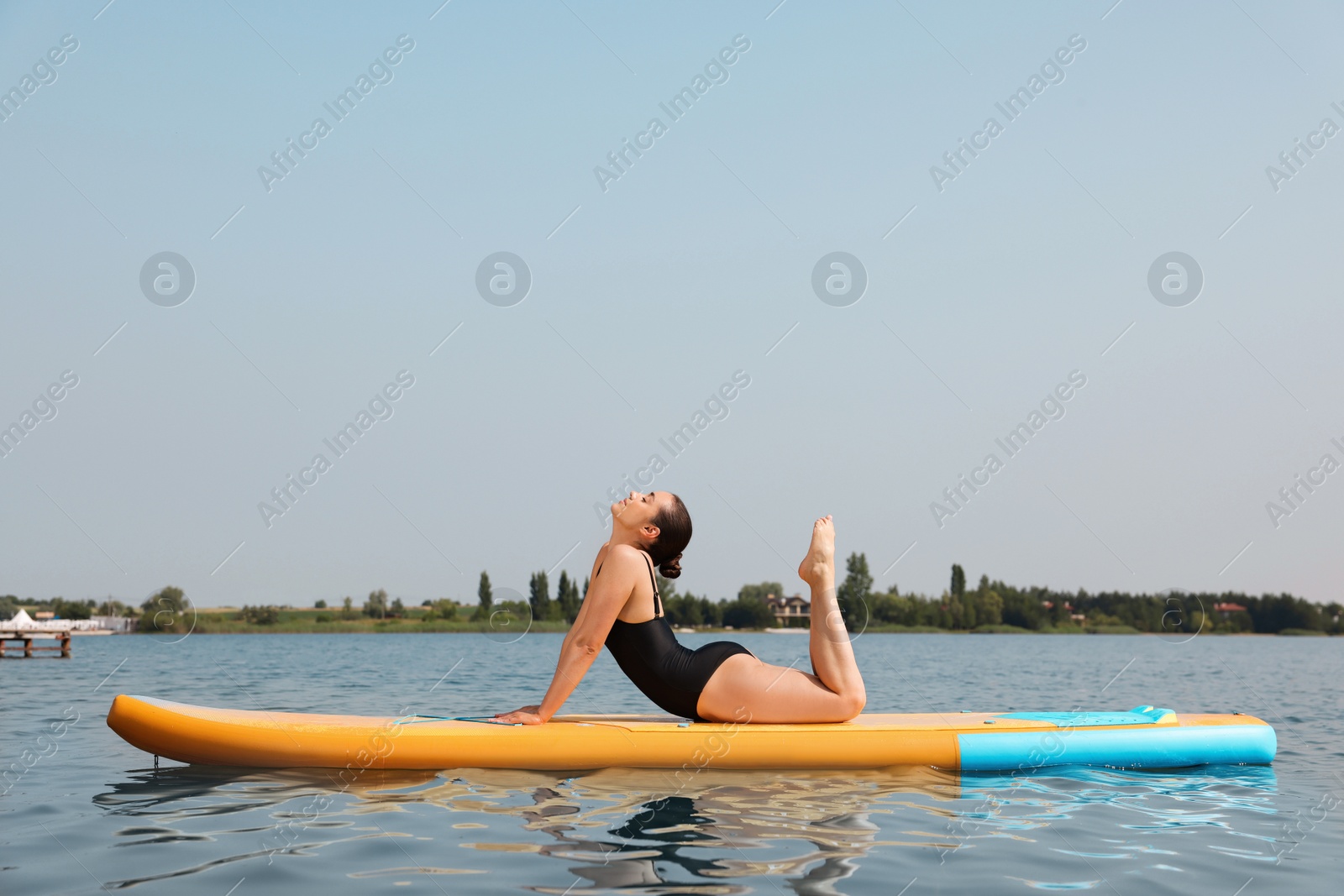 Photo of Woman practicing yoga on SUP board on river