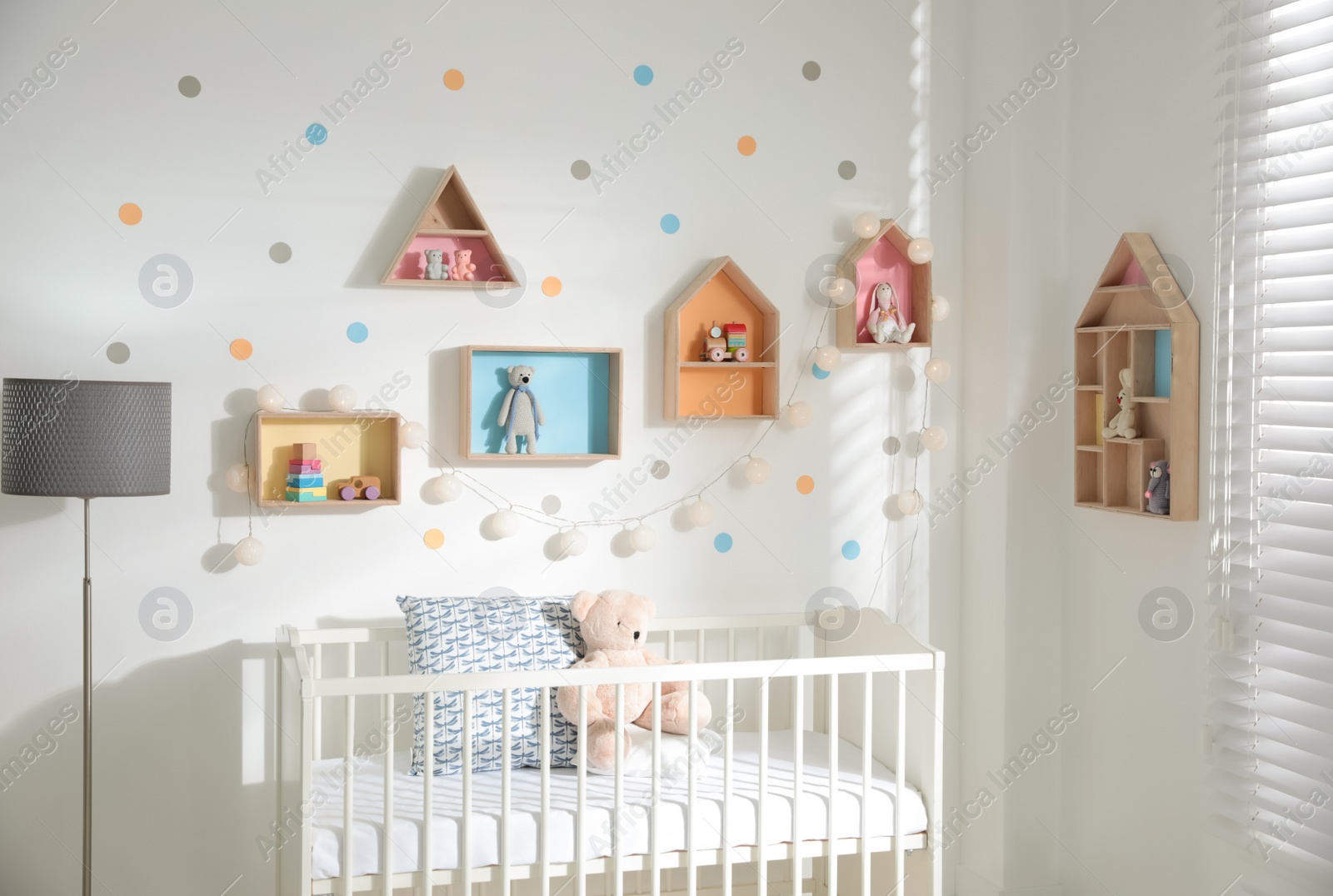 Photo of Cute children's room with house shaped shelves and crib. Interior design