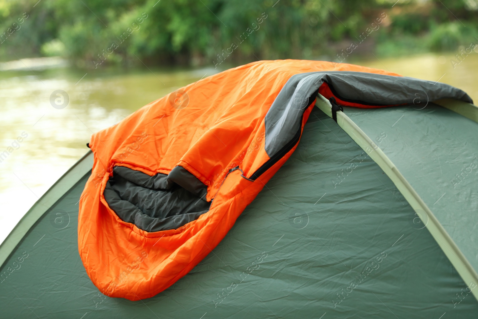 Photo of Tent with sleeping bag outdoors. Camping gear