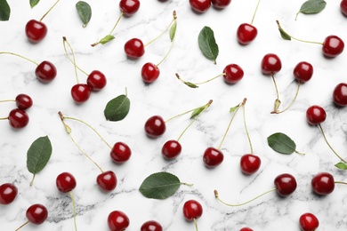 Photo of Delicious cherries on marble background, flat lay