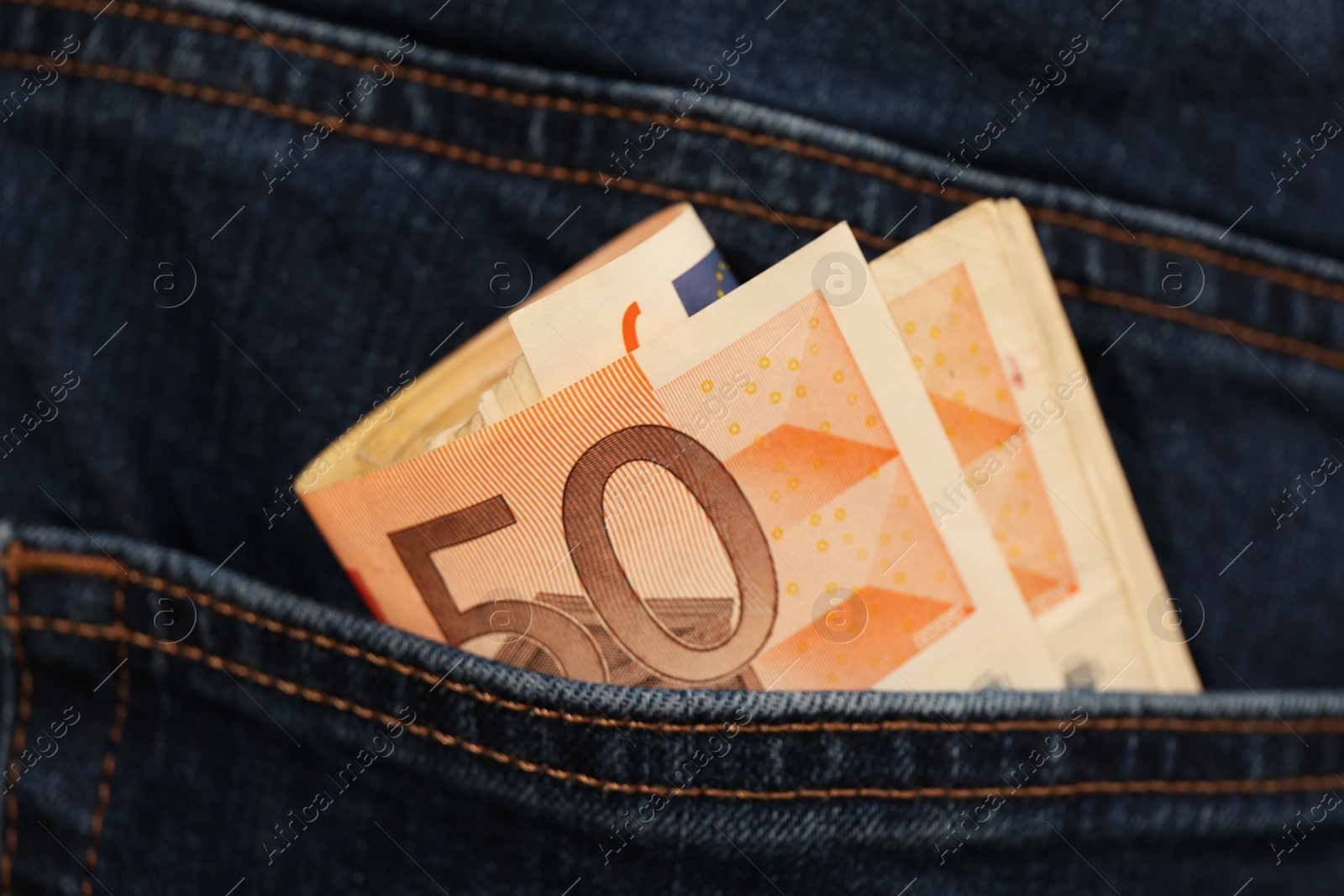 Photo of Euro banknotes in pocket of jeans, closeup. Spending money