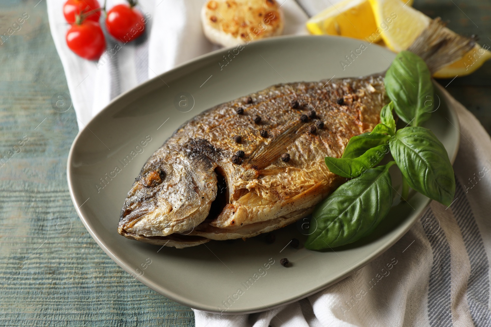 Photo of Delicious dorado fish with basil and spices on wooden table