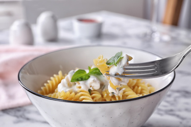 Photo of Delicious pasta with sauce served on white marble table, closeup