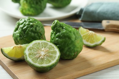 Photo of Whole and cut ripe bergamot fruits on wooden board