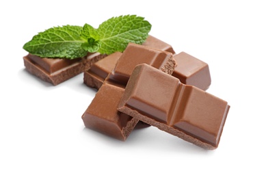 Pieces of milk chocolate with mint on white background