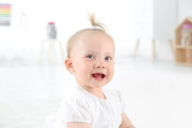 Photo of Adorable baby girl with cute toy at home