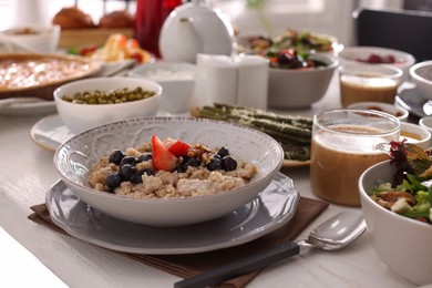 Photo of Oatmeal with fruits and nuts served on buffet table for brunch