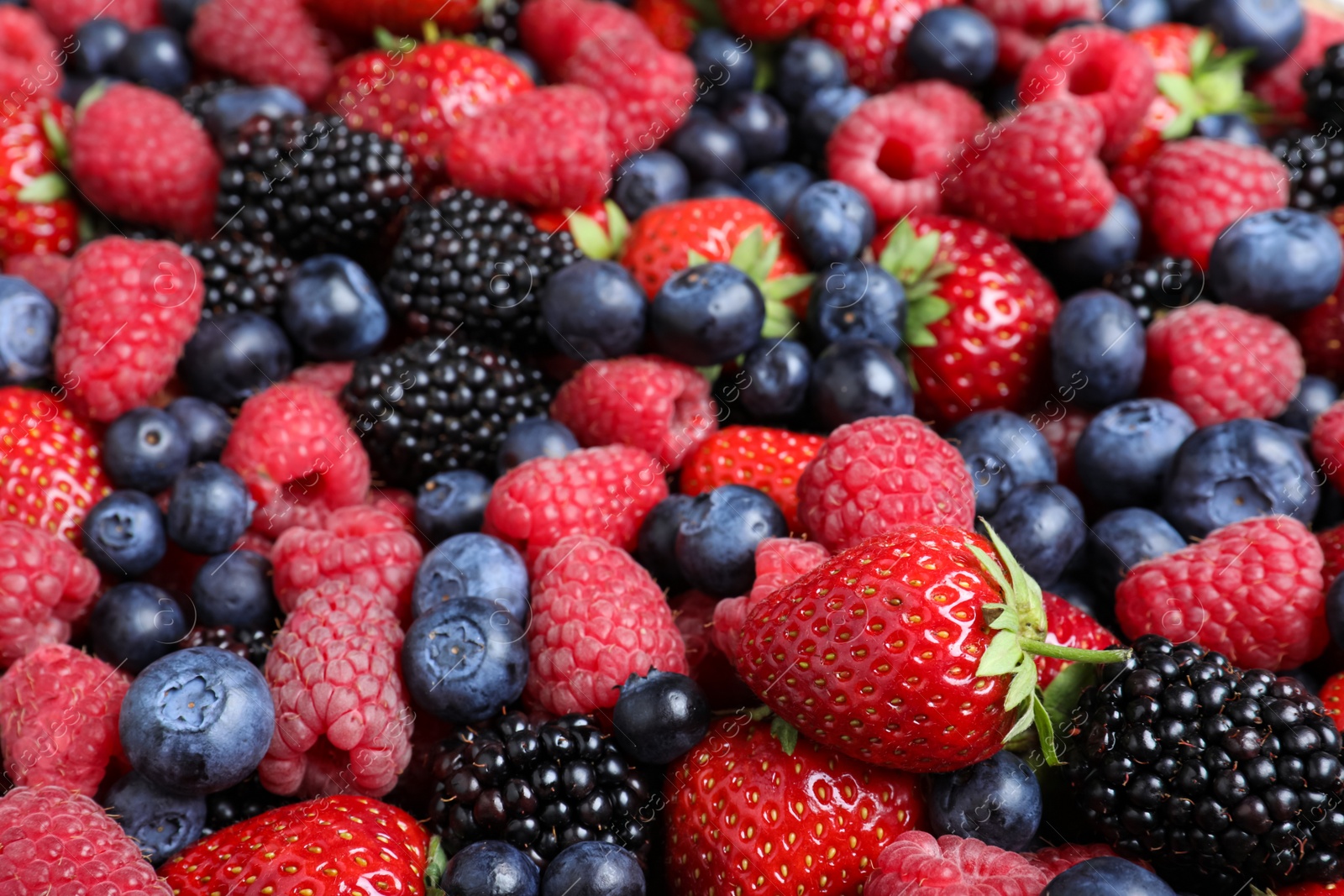 Photo of Mix of different ripe tasty berries as background, closeup view