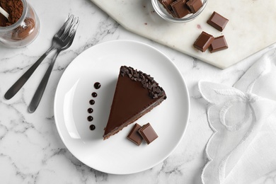 Photo of Delicious fresh chocolate cake served on white marble table, flat lay