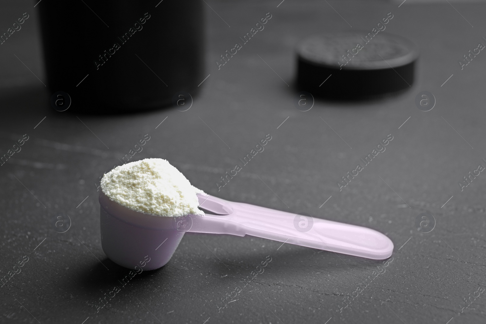 Photo of Scoop of protein powder on black table
