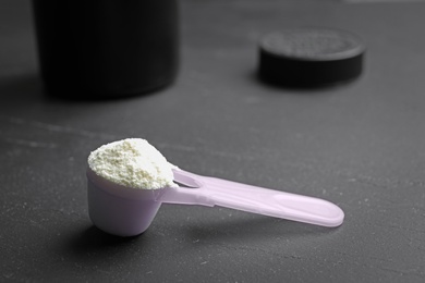 Scoop of protein powder on black table