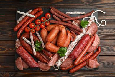 Different tasty sausages on wooden table, top view