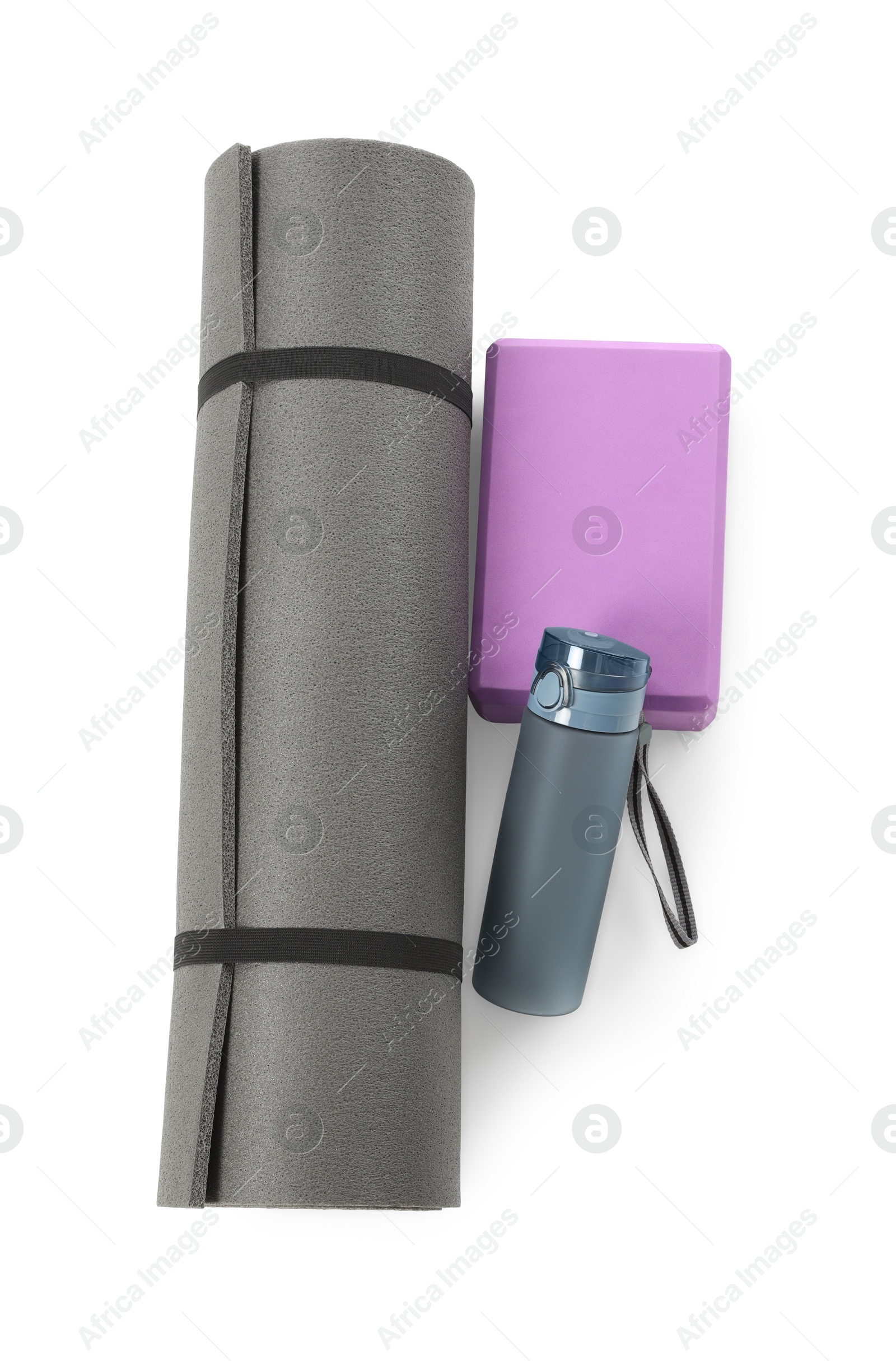 Photo of Grey exercise mat, yoga block and bottle of water isolated on white, top view