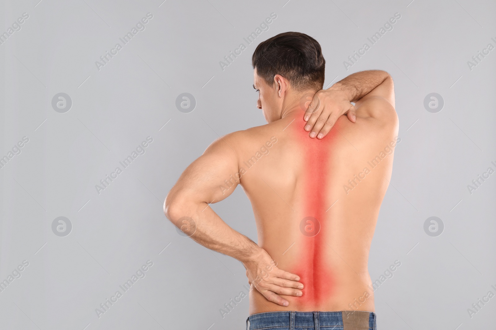 Image of Man suffering from pain in back on light grey background