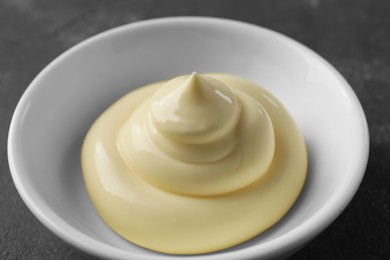 Photo of Fresh mayonnaise sauce in bowl on grey table, closeup