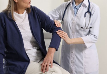 Arthritis symptoms. Doctor examining patient's elbow in hospital