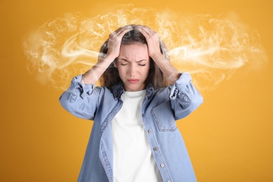 Image of Stressed and upset young woman on yellow background