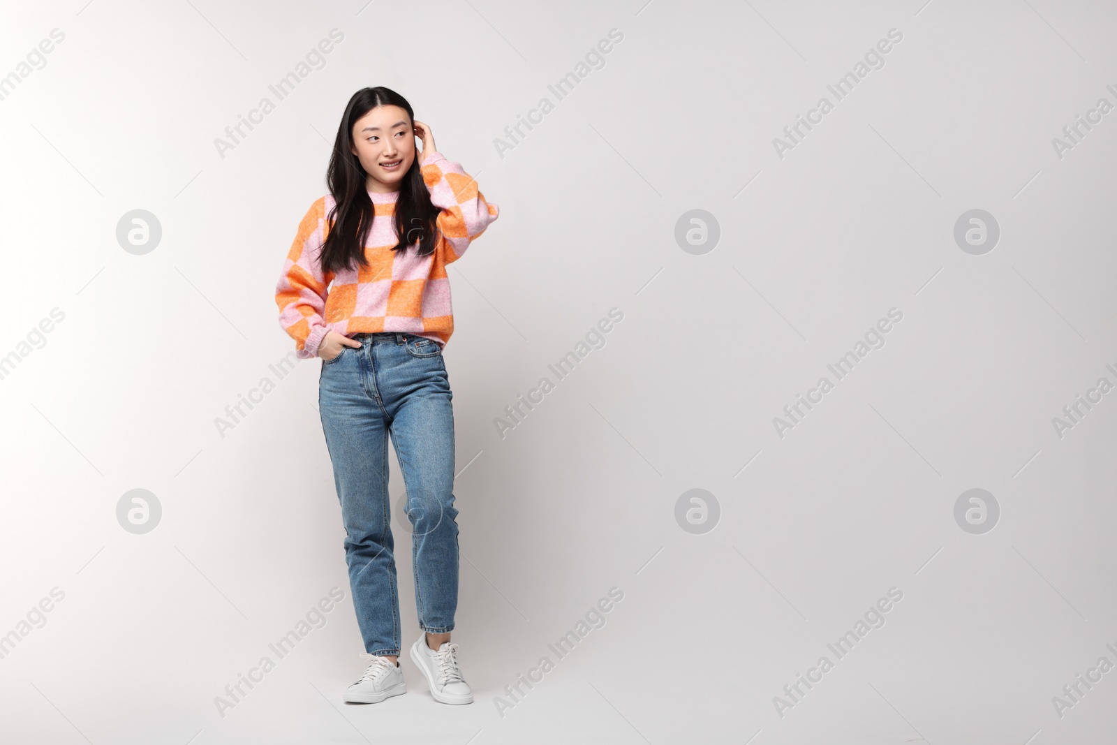 Photo of Full length portrait of smiling woman on light background. Space for text