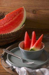 Photo of Fresh juicy watermelon and fork on wooden table