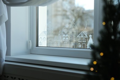 Beautiful drawing made of artificial snow on window at home. Christmas decor