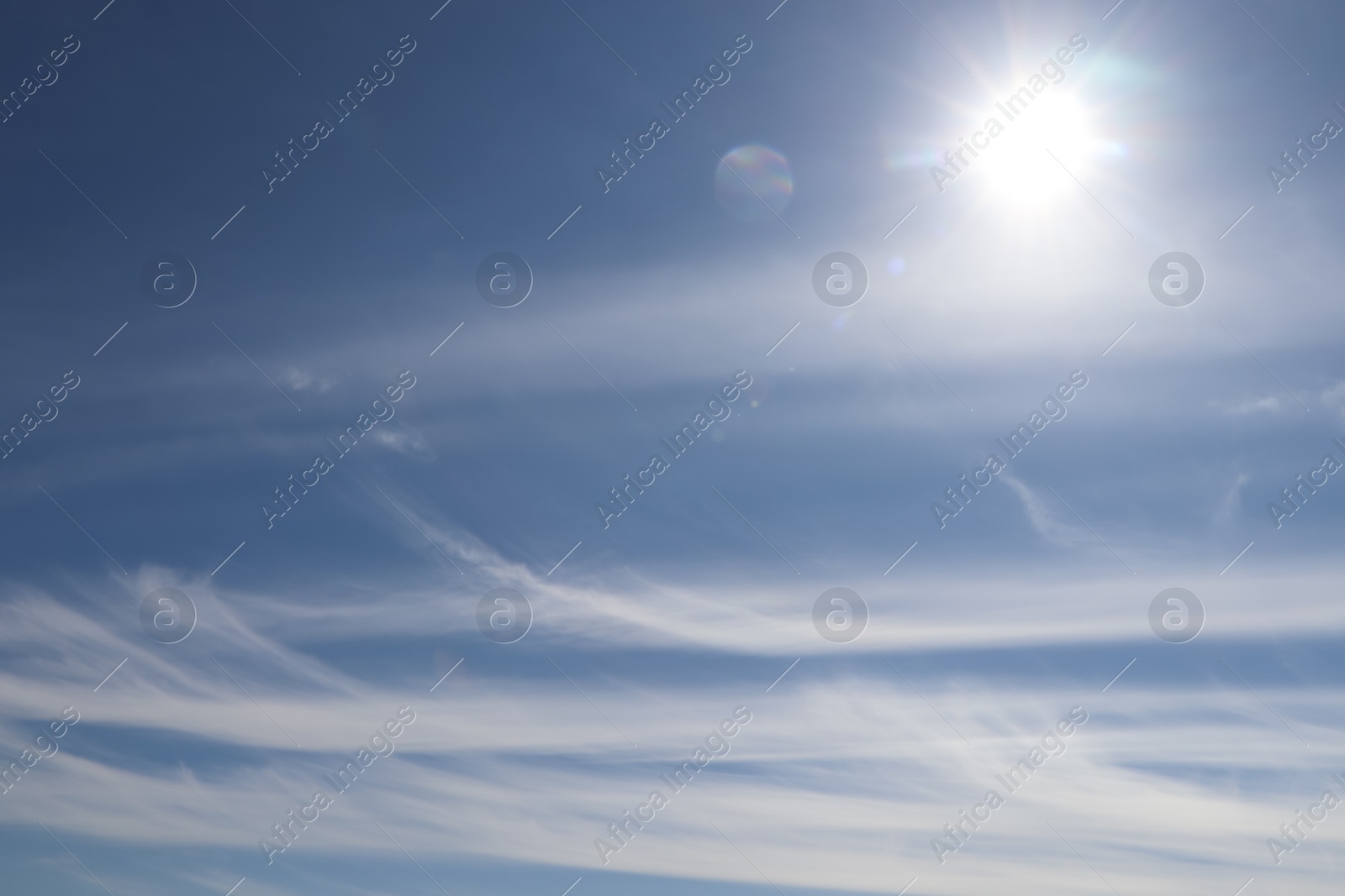 Photo of Bright sun and fluffy white clouds in blue sky