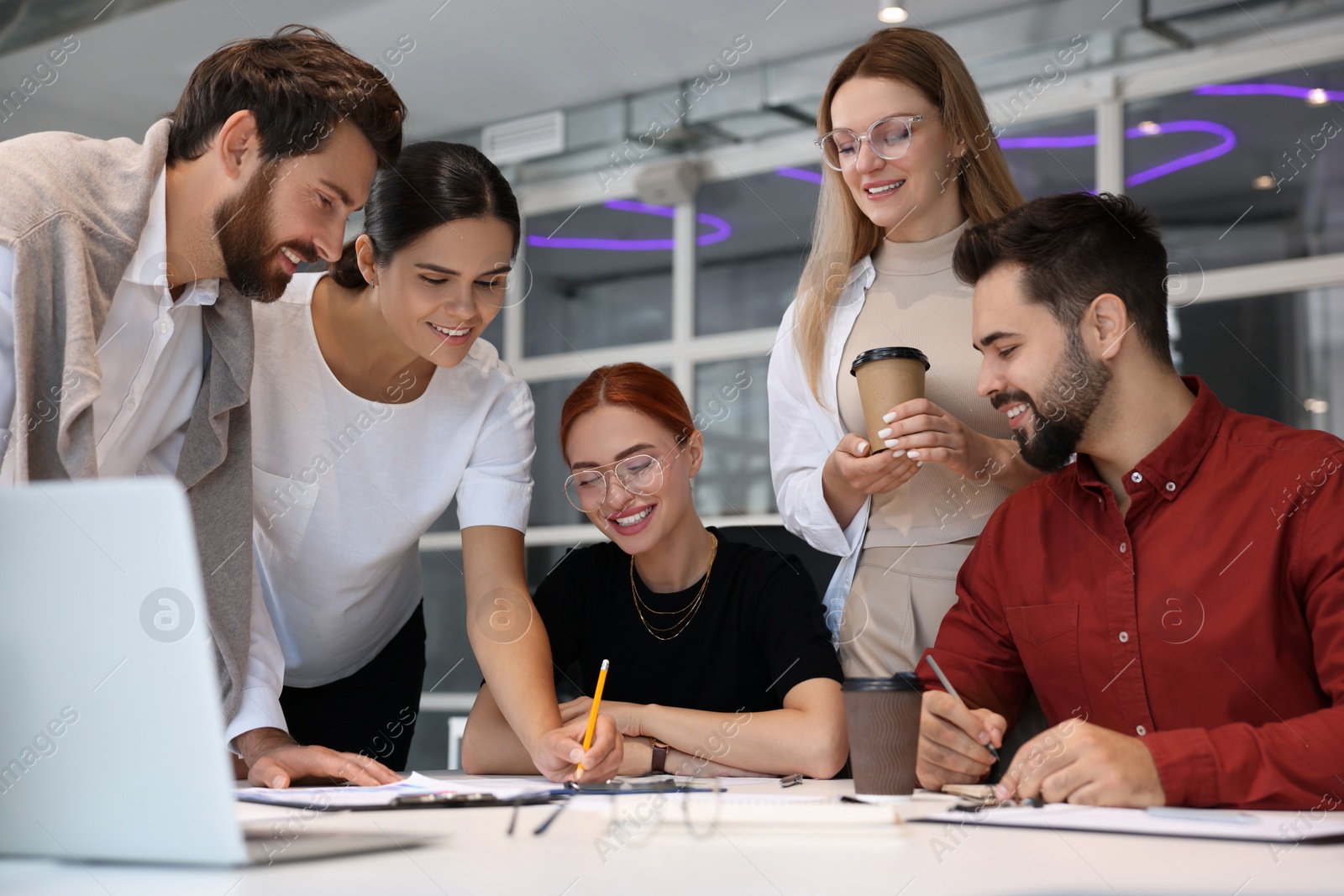 Photo of Team of employees working together in office