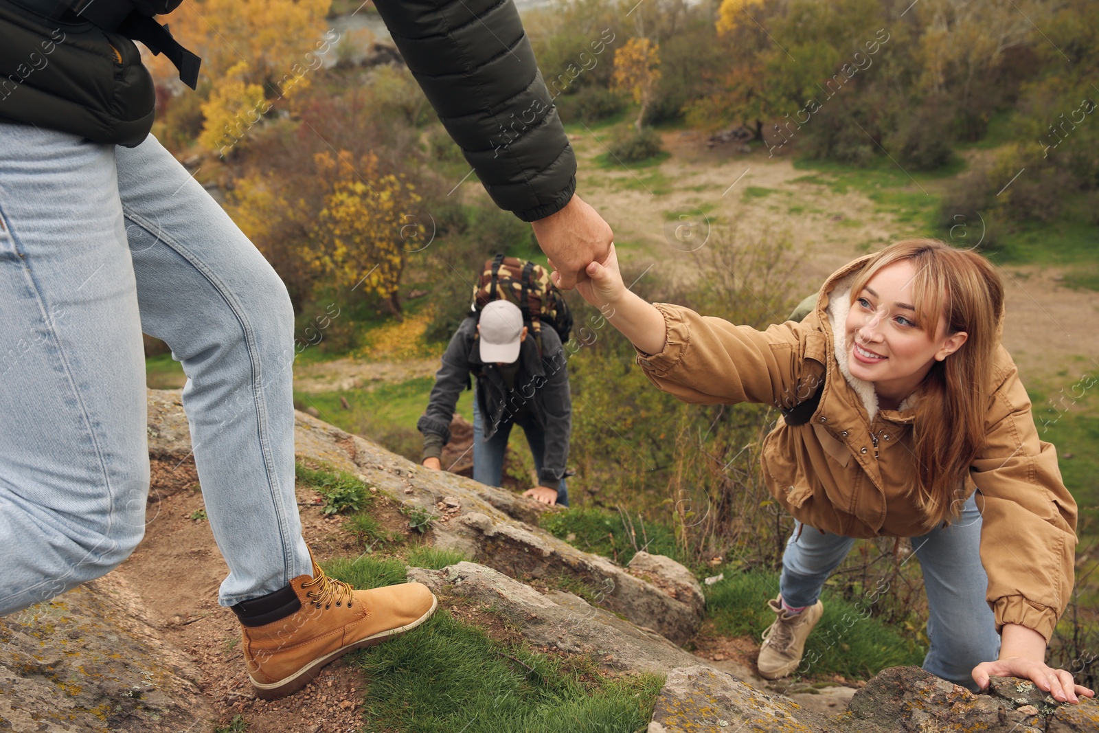 Photo of Group of hikers with backpacks climbing up mountains