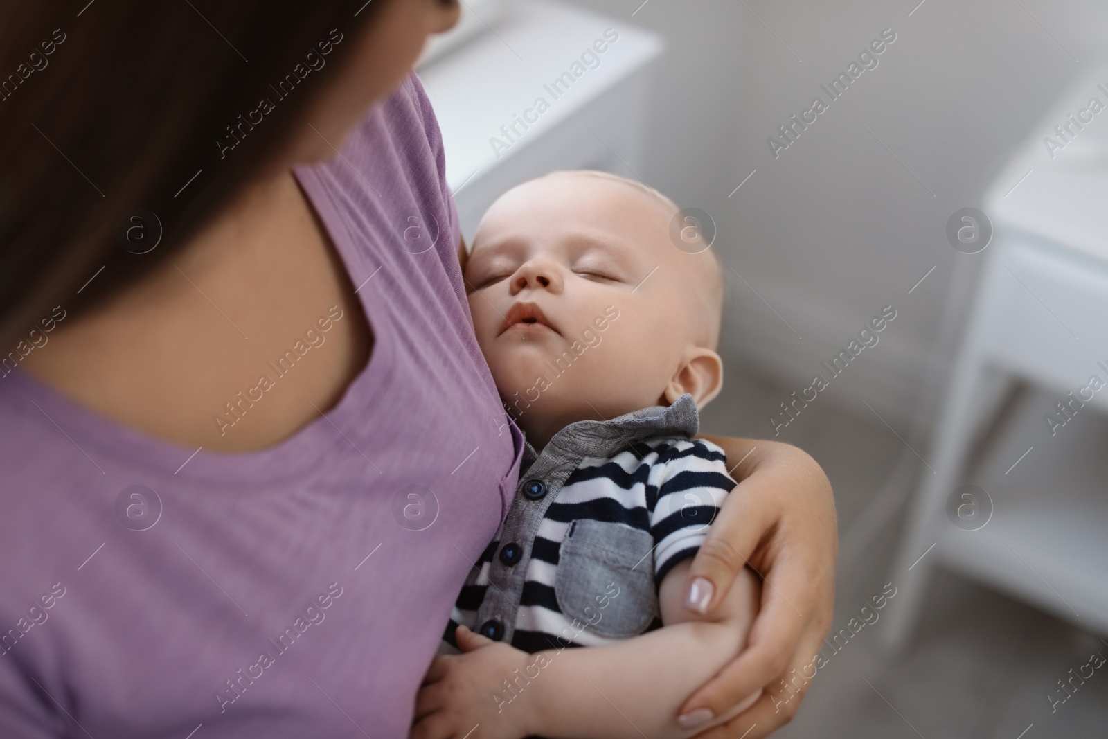 Photo of Mother with her sleeping baby at home, closeup view