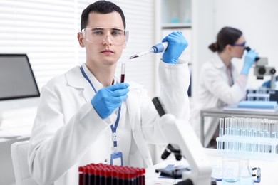 Scientist dripping sample into test tube in laboratory