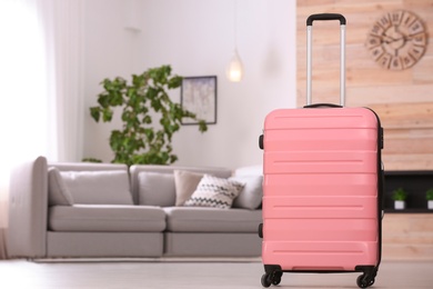 Photo of Colorful suitcase packed for journey in living room. Space for text