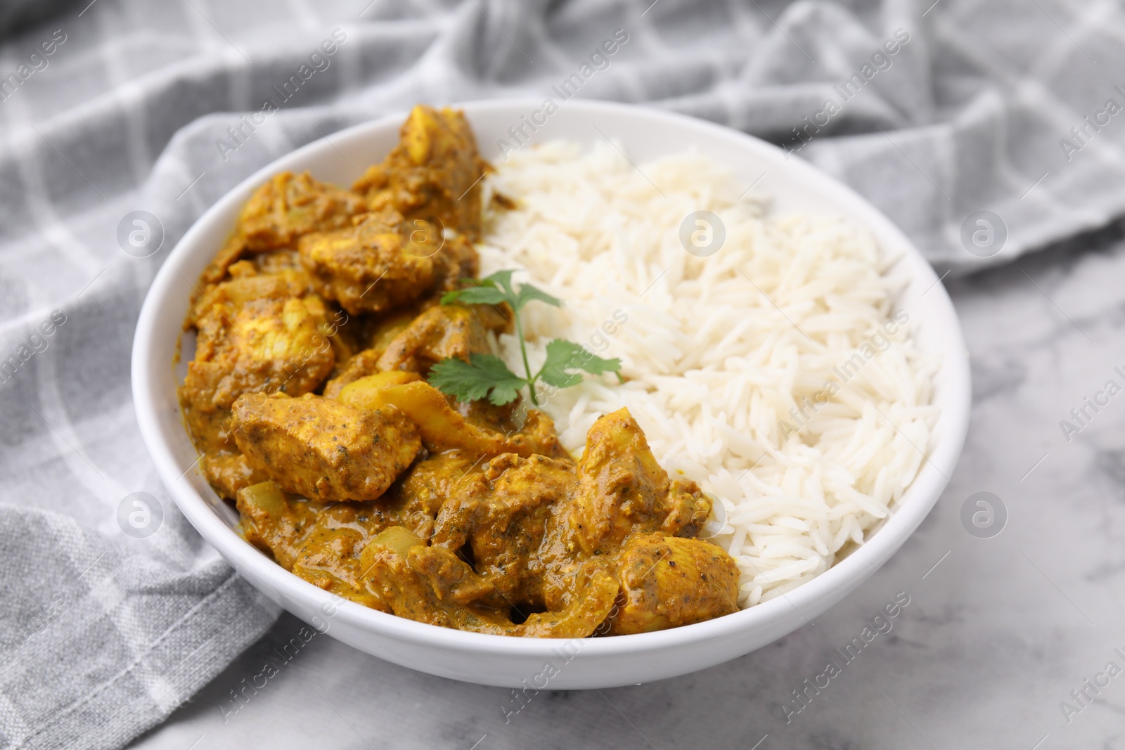 Photo of Delicious chicken curry with rice on white marble table, closeup