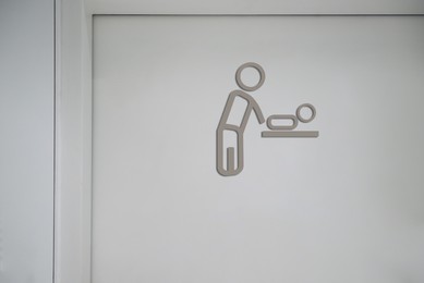 Baby changing station sign on white wall