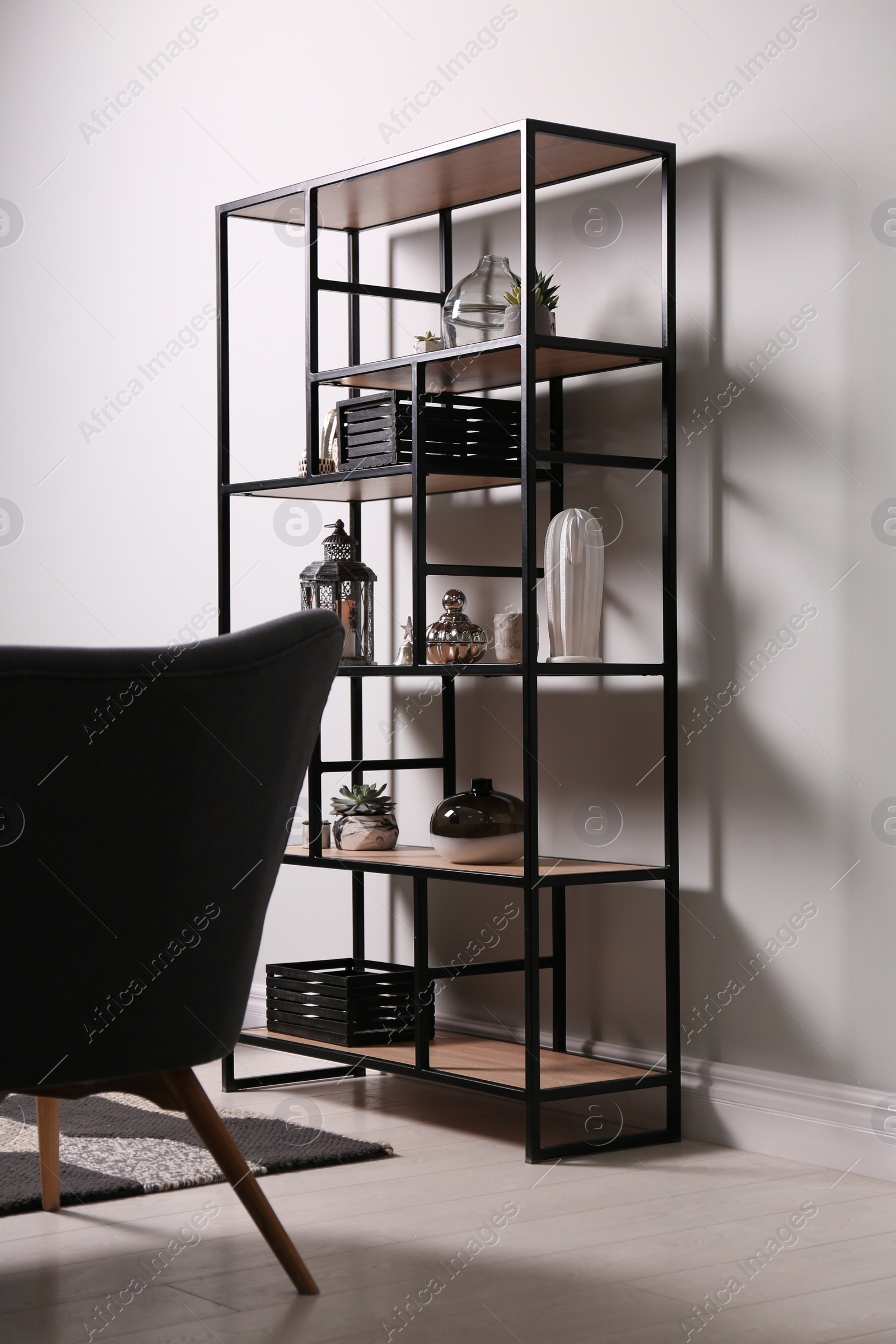 Photo of Shelving with different decor and houseplants near white wall in room. Interior design