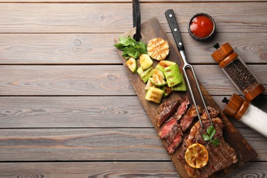 Photo of Delicious grilled beef steak and vegetables served on wooden table, flat lay. Space for text