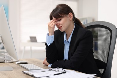 Photo of Overwhelmed woman suffering at table in office