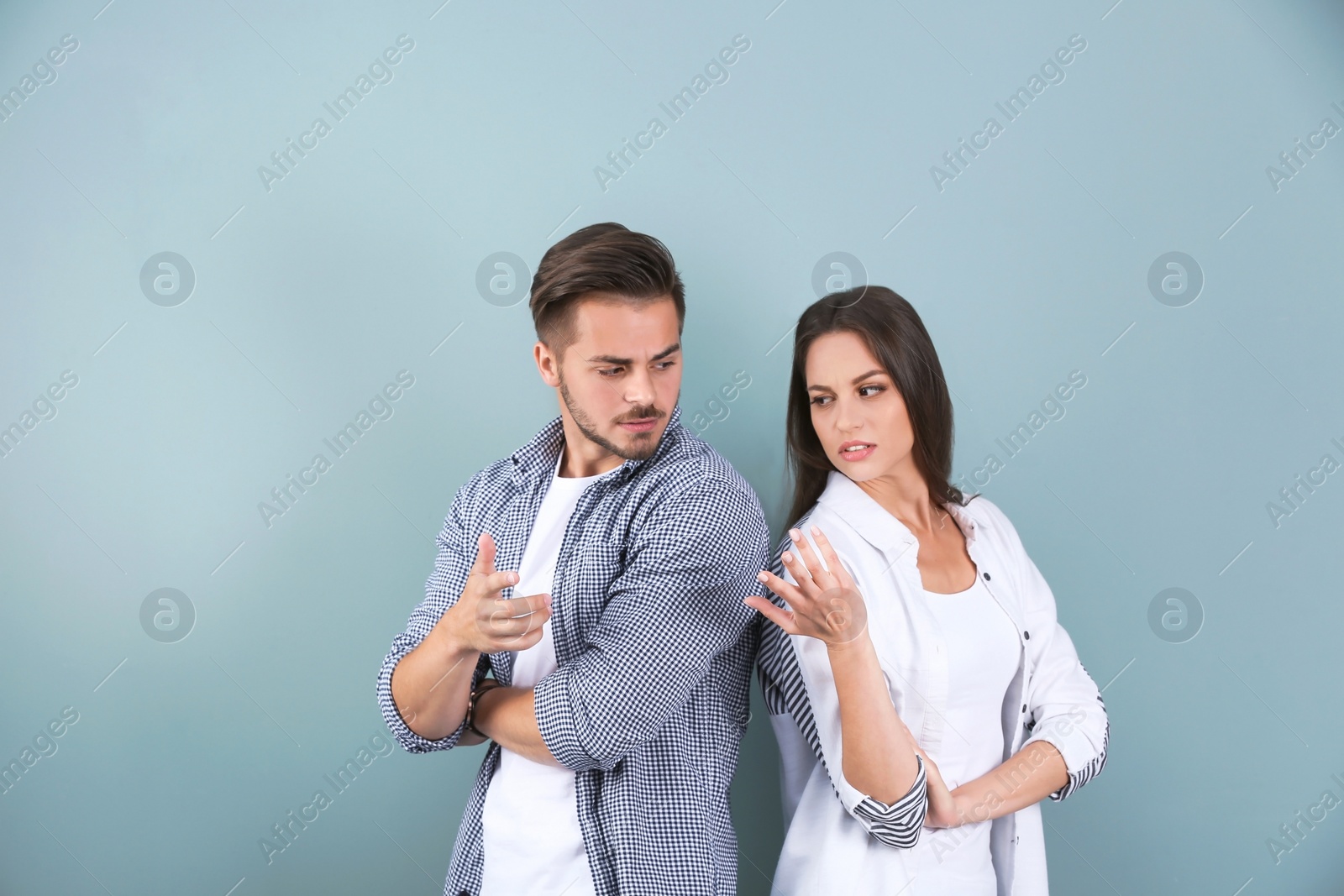 Photo of Upset young couple on color background. Relationship problems