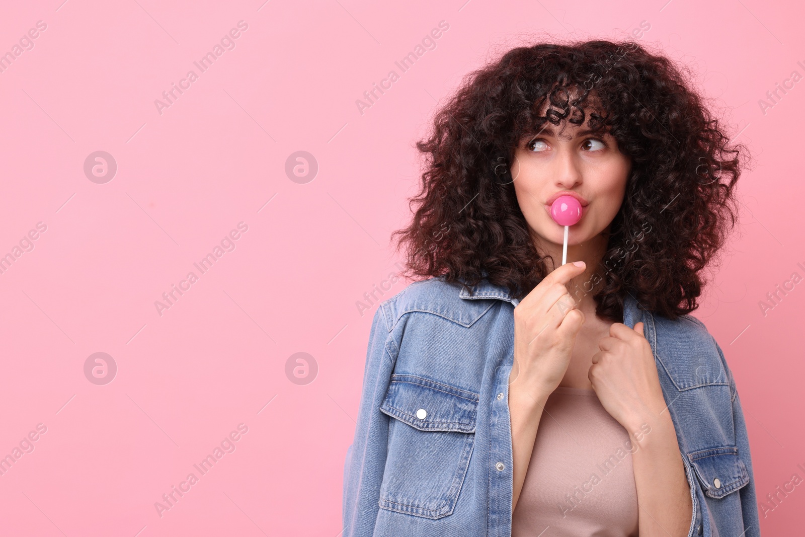 Photo of Beautiful woman with lollipop on pink background, space for text